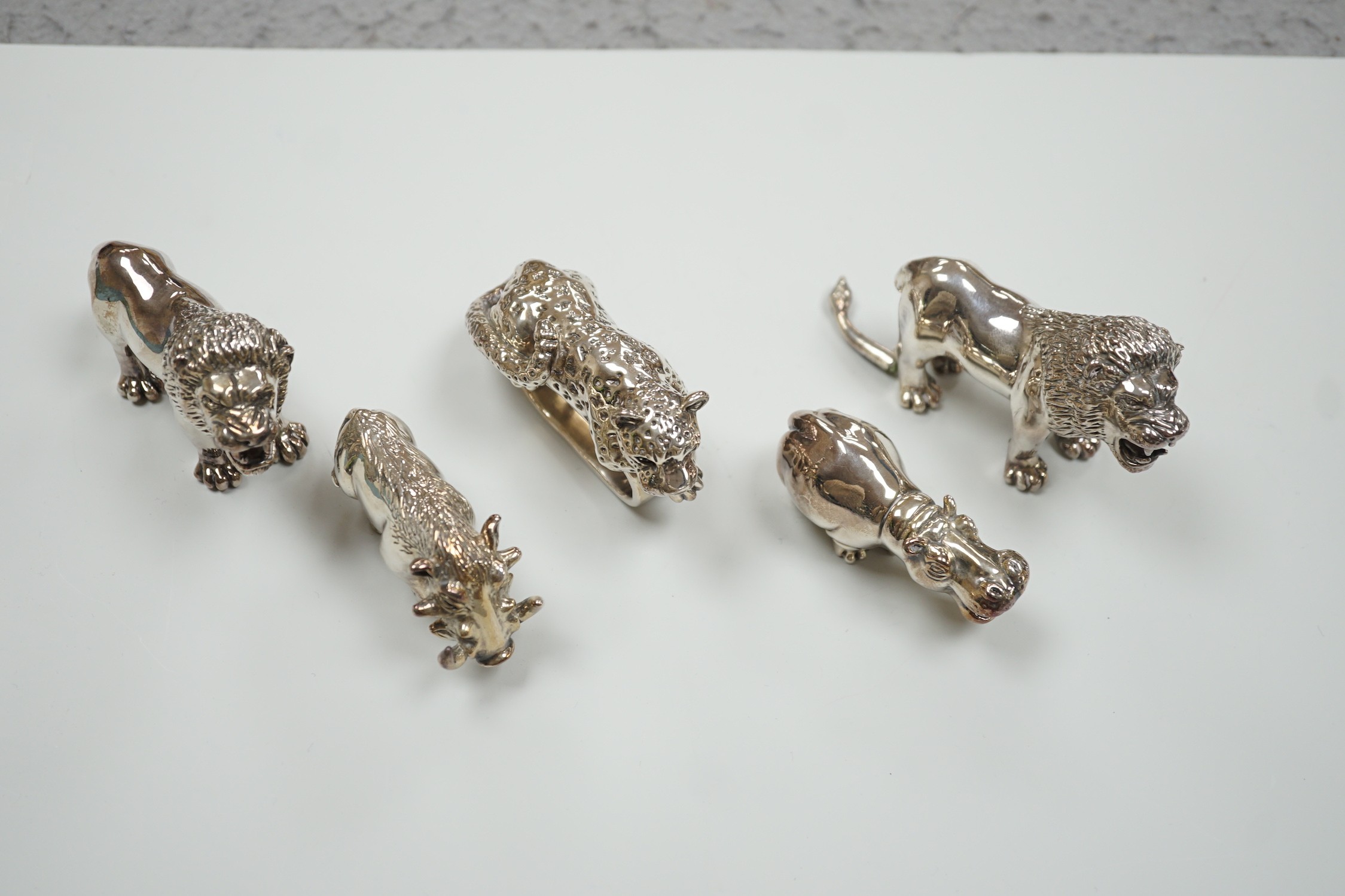 Four modern 925 overlaid miniature models of animals including two lions and a similar leopard napkin ring (one lion a.f.).